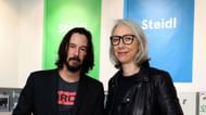 Reeves and Grant at a book promotion event (via Getty Images / Pierre Suu)